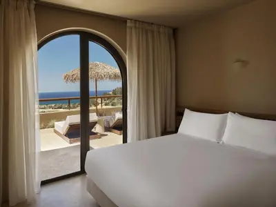 a bedroom with a bed and a view of the beach at Tella Thera, a Member of Design Hotels in Kissamos