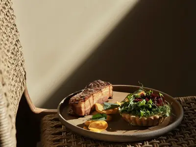a plate of food with meat and salad on a table at Tella Thera, a Member of Design Hotels in Kissamos