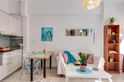 a kitchen and a living room with a table and a couch at Backyard Art Studio in Chania Town