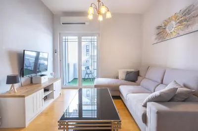 a living room with a couch and a tv at Cozy Apartment 50m to beach, 5min walk to Old Town in Chania Town