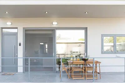 a dining room with a table and chairs on a patio at Galanidis Luxury Apartments in Perivólia