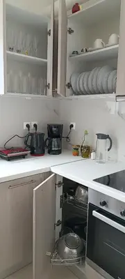 a kitchen with a stove and some dishes on shelves at Christos in Kissamos