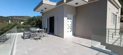 a patio with a table and chairs on a balcony at Christos in Kissamos