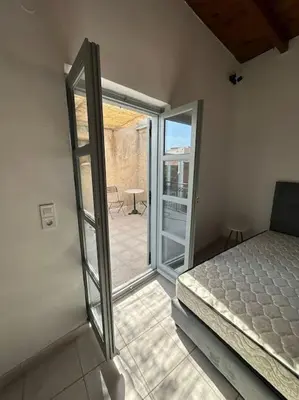 a bedroom with a bed and a sliding glass door at Casa Di Sarpaki in Chania Town