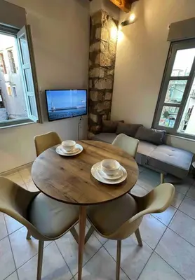 a living room with a wooden table and chairs at Casa Di Sarpaki in Chania Town