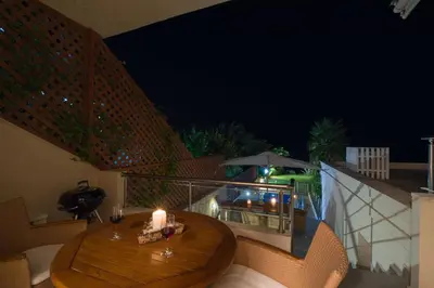 a table on a balcony with a candle on it at The Seaside Villa in Chania Town
