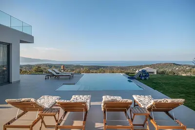 a group of chairs sitting on the patio of a house at Villa Levante With Sea View in Plataniás