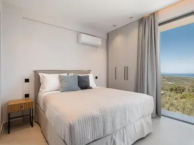 a bedroom with a bed and a large window at Villa Levante With Sea View in Plataniás