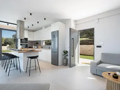 a kitchen and living room with a couch and a table at Villa Levante With Sea View in Plataniás