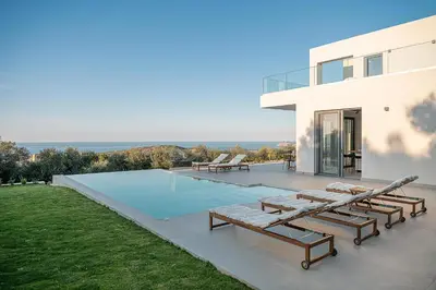 a villa with a swimming pool and a house at Villa Zefyros With Sea View in Plataniás