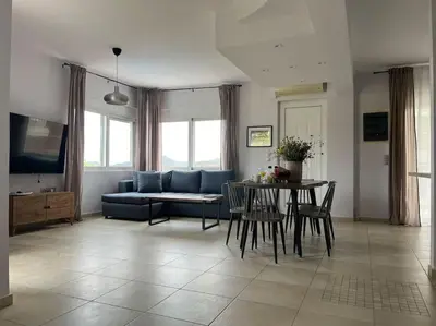 a living room with a blue couch and a table at Ion villa - Xirokampi in Ayiá