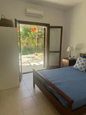 a bedroom with a bed and a door to a garden at Villa Europa Ravdoucha Private Pool and Amazing View in Ravdhoúkha