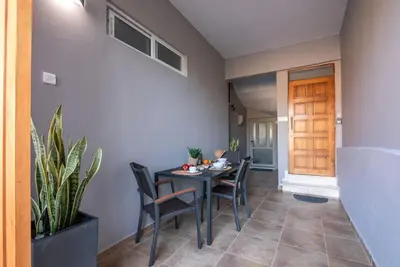 a dining room with a table and chairs and a plant at Modern House in the Old Town in Chania Town