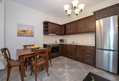 a kitchen with a table and a stainless steel refrigerator at Villa Olivia in Chania Town
