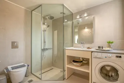 a bathroom with a shower and a washing machine at Koutris Apartment 1 in Falasarna