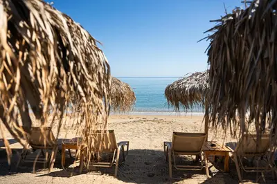 a group of chairs and umbrellas on a beach at Seascape Kalyves in Kalyves