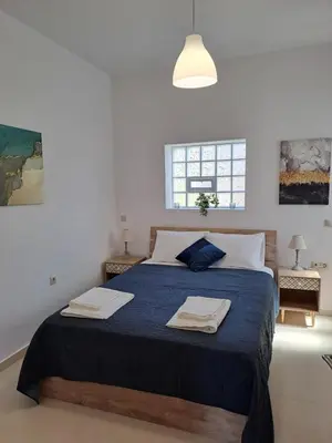 a bedroom with a bed with two towels on it at Olea Homes in Plátanos
