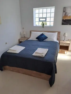 a bedroom with a large bed with towels on it at Olea Homes in Plátanos