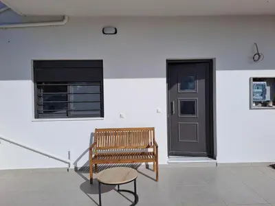 a bench in a room with a window and a door at Olea Homes in Plátanos