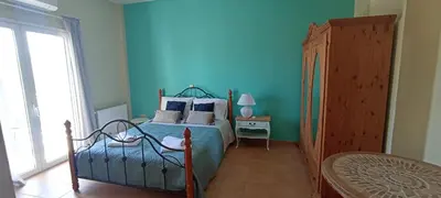 a bedroom with a bed with blue walls and a window at Casa Lazareta in Chania Town