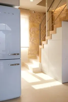 a kitchen with a staircase and a white refrigerator at Once Upon a Home in Chania Town