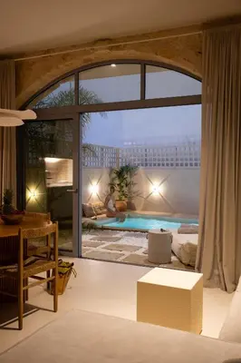 a living room with a large window and a swimming pool at Once Upon a Home in Chania Town
