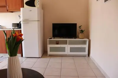 a kitchen with a white refrigerator and a tv at Down Town apartment 27a in Chania Town