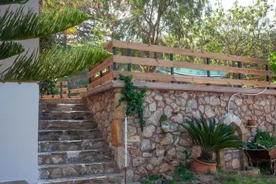 a stone retaining wall with a wooden bench and stairs at Chania Paradise Retreat in Rodhopós
