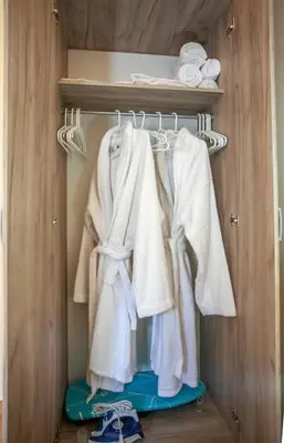 a closet with white clothes hanging on a rack at Chania Paradise Retreat in Rodhopós