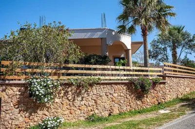a house on a stone wall with flowers at Chania Paradise Retreat in Rodhopós