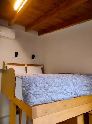 a bedroom with a bed with a blue comforter at Ploumi in Chania Town