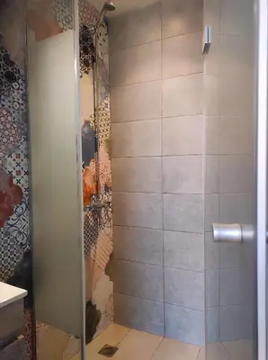 a shower with a glass door in a bathroom at Ploumi in Chania Town