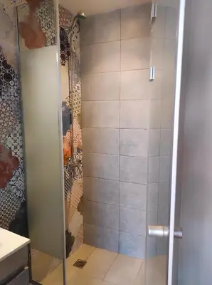 a shower with a glass door in a bathroom at Ploumi in Chania Town
