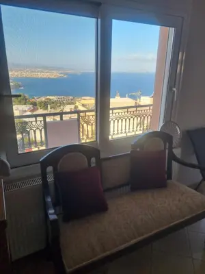 a bench in front of a window with a view of the ocean at Villa Nancy in Chania Town