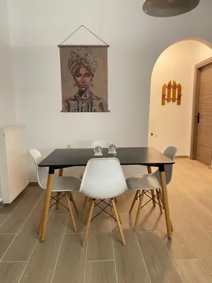 a dining room table with chairs and a painting on the wall at Moments in Áptera