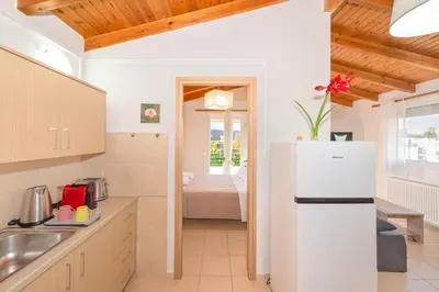 a kitchen with a white refrigerator in a room at Sea Stars Cozy Suite in Souda