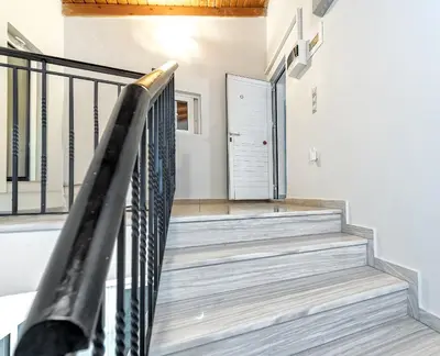 a staircase in a house with a black railing at Sea Stars Cozy Suite in Souda