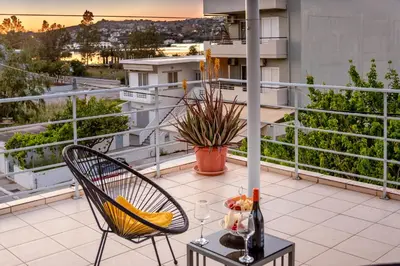 a balcony with a table and a chair on a balcony at Sea Stars Cozy Suite in Souda