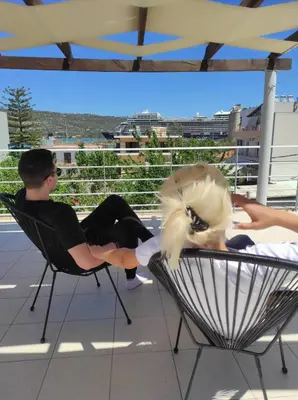 a man and a woman sitting in chairs on a balcony at Sea Stars Cozy Suite in Souda