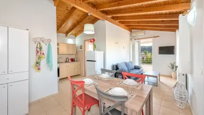 a kitchen and living room with a table and chairs at Sea Stars Cozy Suite in Souda