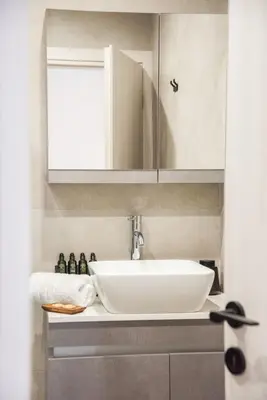 a bathroom with a sink and a mirror at Minimal Chic Retreat Suite in Chania Town