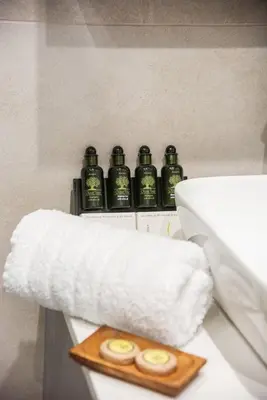 a bathroom with a toilet with four bottles on it at Minimal Chic Retreat Suite in Chania Town