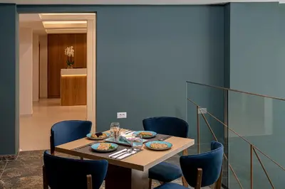 a dining room with a table and blue chairs at Miss Marrone City Hotel in Chania Town