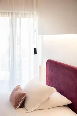 a bedroom with a bed with a pillow and a window at Miss Marrone City Hotel in Chania Town