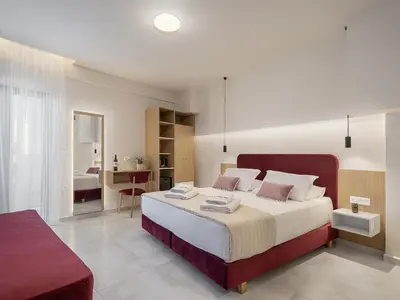 a bedroom with a large bed with a red headboard at Miss Marrone City Hotel in Chania Town