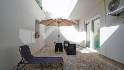 a patio with a chair and an umbrella in a building at Odyssey Residences 2 in Chania Town