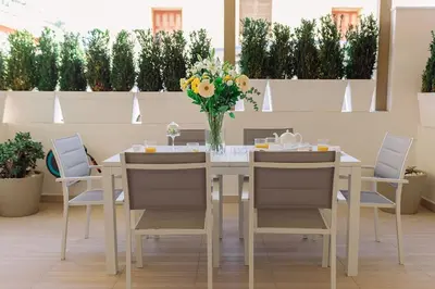 a dining room table with chairs and a vase of flowers at Nobel apartment, Chania Town in Chania Town