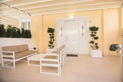 a porch with a couch and chairs and a door at Nobel apartment, Chania Town in Chania Town