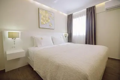 a bedroom with a white bed and a window at Nobel apartment, Chania Town in Chania Town