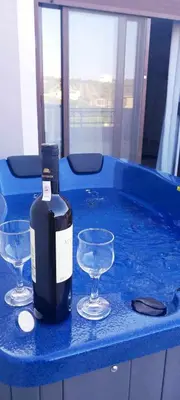 a bottle of wine and two glasses in a hot tub at Emmanuel apartment in Agia Marina Nea Kydonias